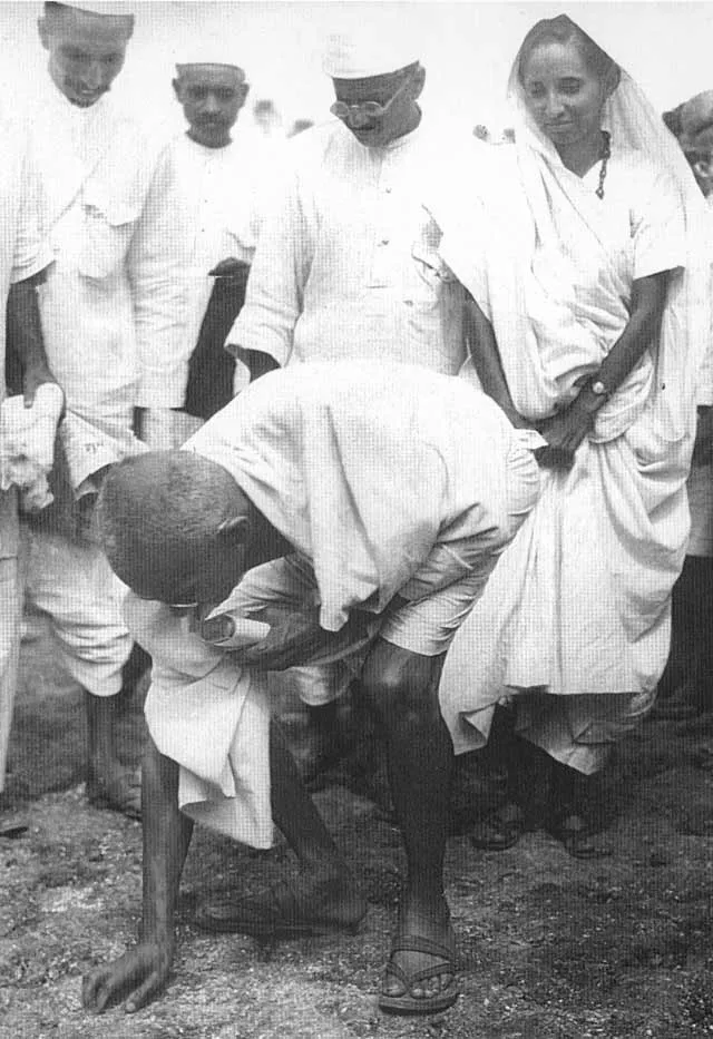 Gandhi Ji picked up grains of salt at the end of his march. Behind him is his second son Manilal Gandhi and Mithuben Petit.